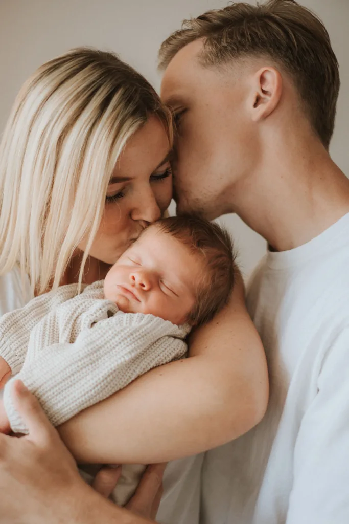 Baby shooting Babyfotografie Baby geborgen in Mama und Papas Arm
